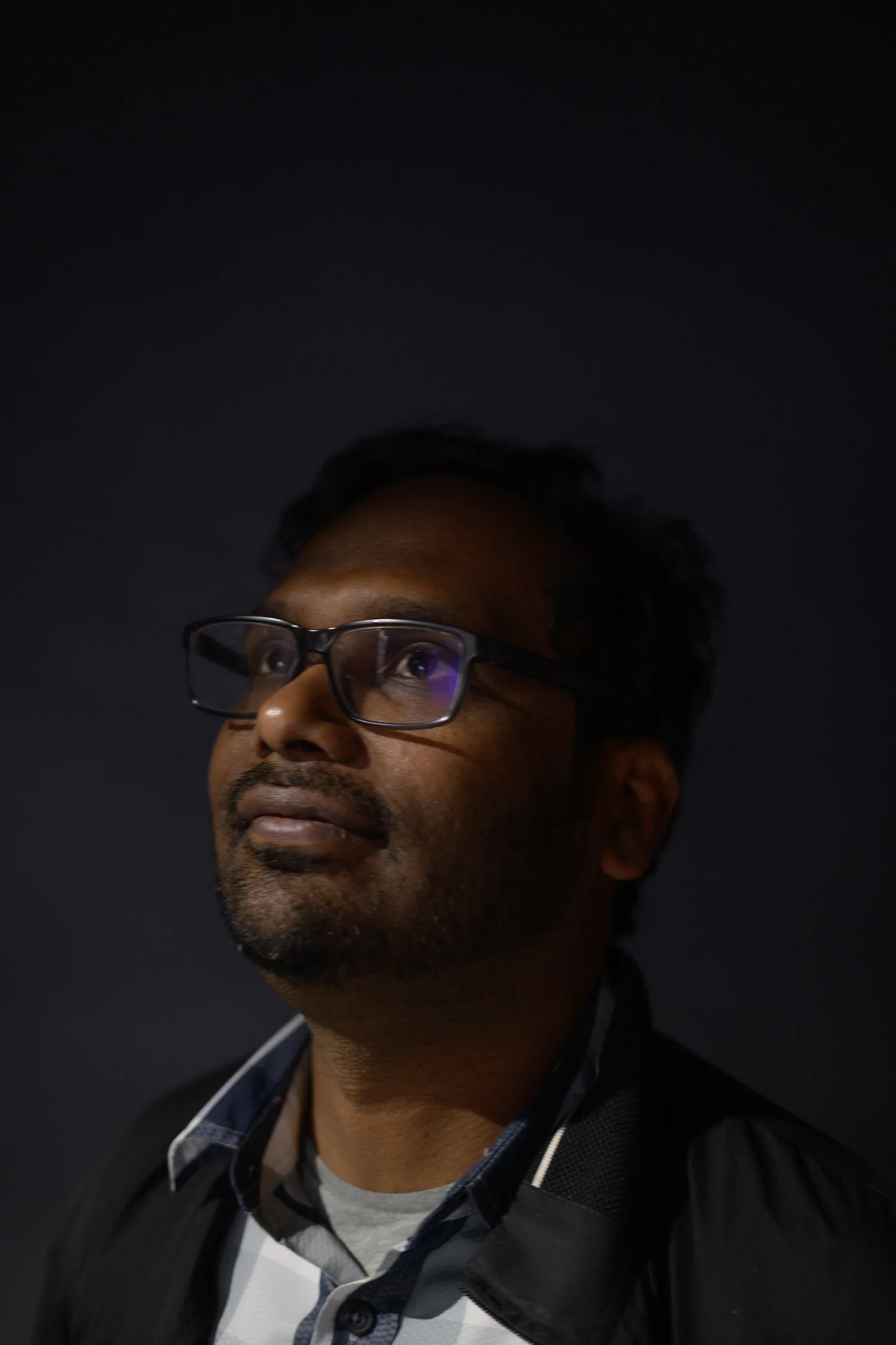 Man looking upward in controlled low-key light