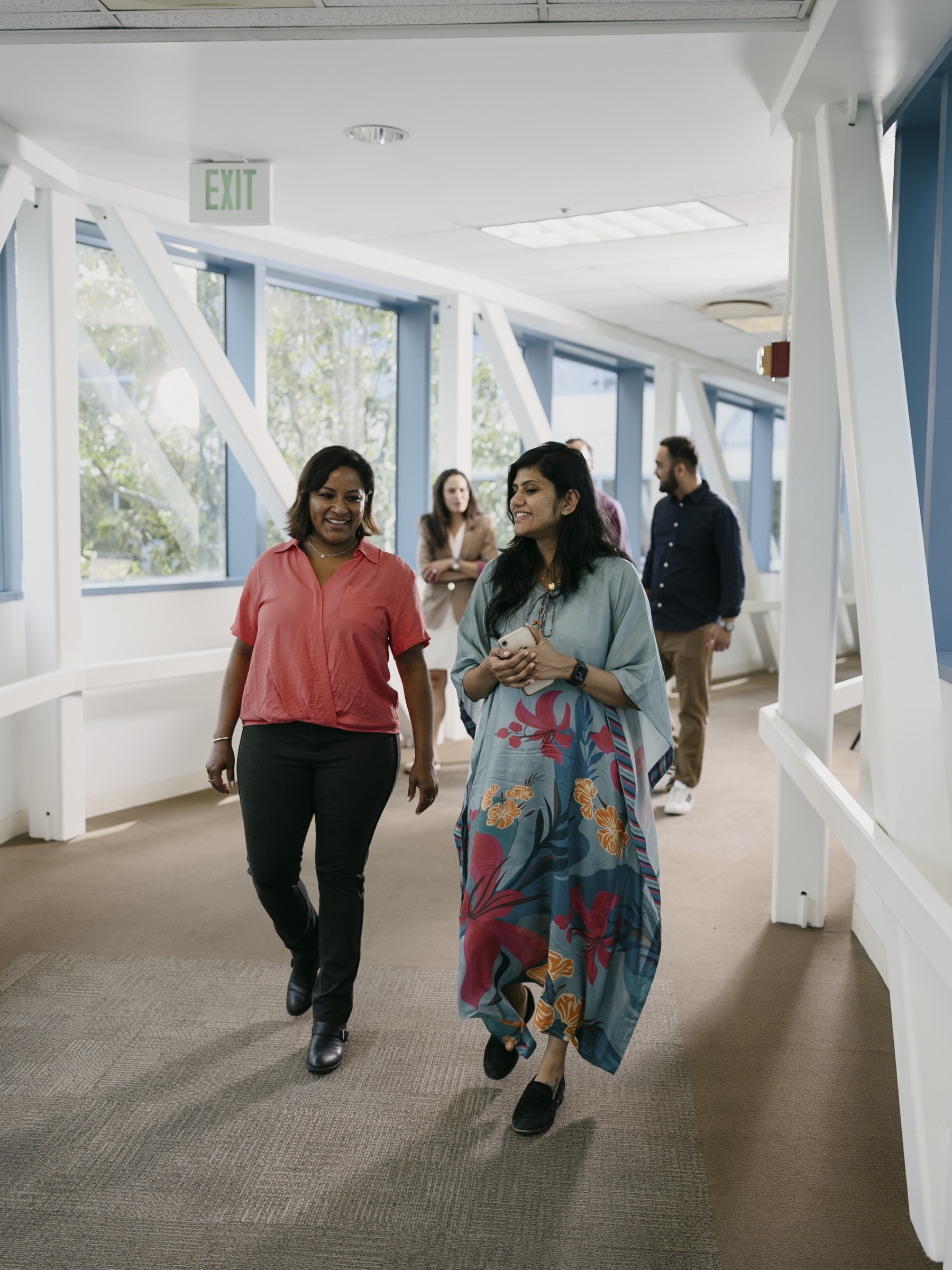 Colleagues walking together through a bright workplace