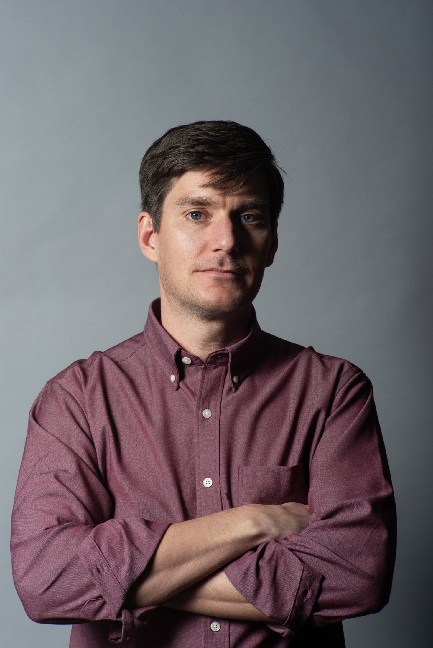 Studio portrait of a man in a burgundy shirt